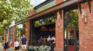 Couple walking past a brick brewery building.
