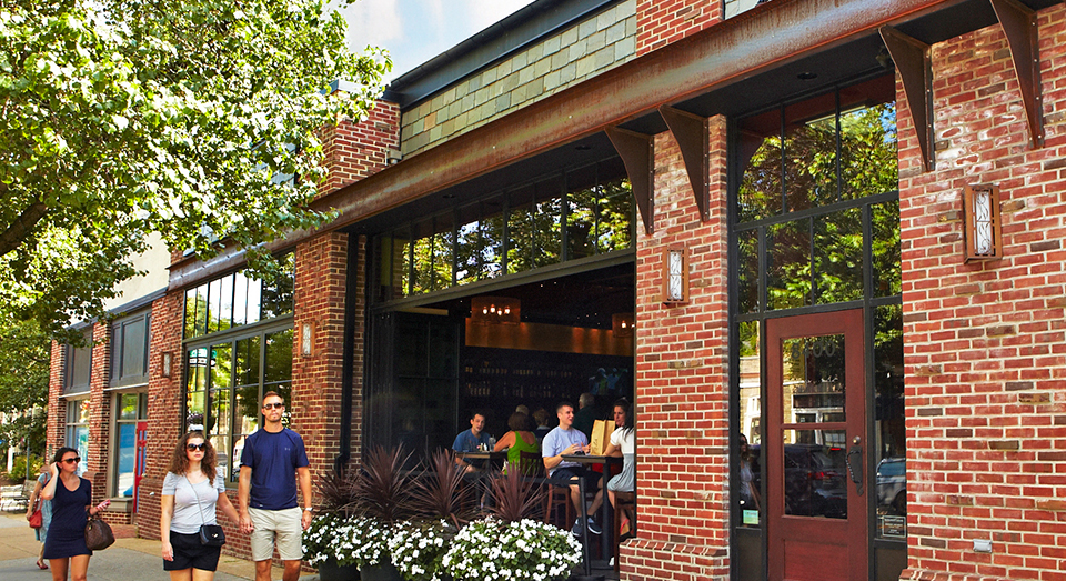 Couple walking past a brick brewery building.