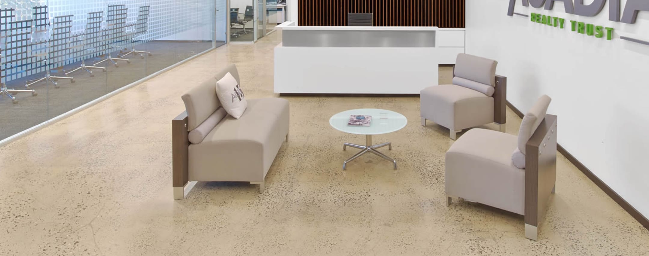 Modern office waiting area with seating and a low table.